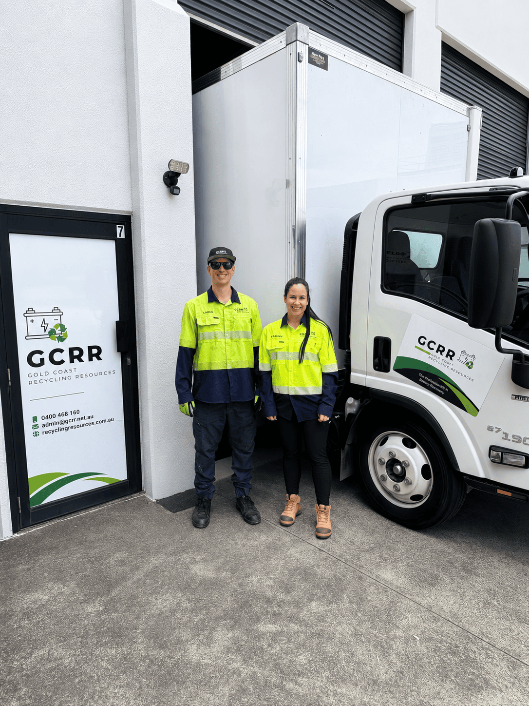 Managing Director Lance Brooks and Shannon in high-visibility uniforms standing outside the Gold Coast Recycling Resources office next to a branded company truck